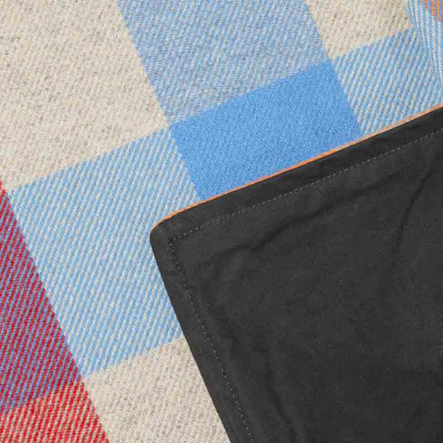 Close up product shot of Wool and Wax Rainbow Blanket showing the checked pattern and waxed backing finish