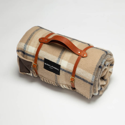 British picnic blanket in wool in beige and light brown checks with a tan leather strap