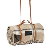 Luxury rolled beige wool picnic blanket in beige with check pattern and elegant tan leather shoulder strap — by Heating & Plumbing London