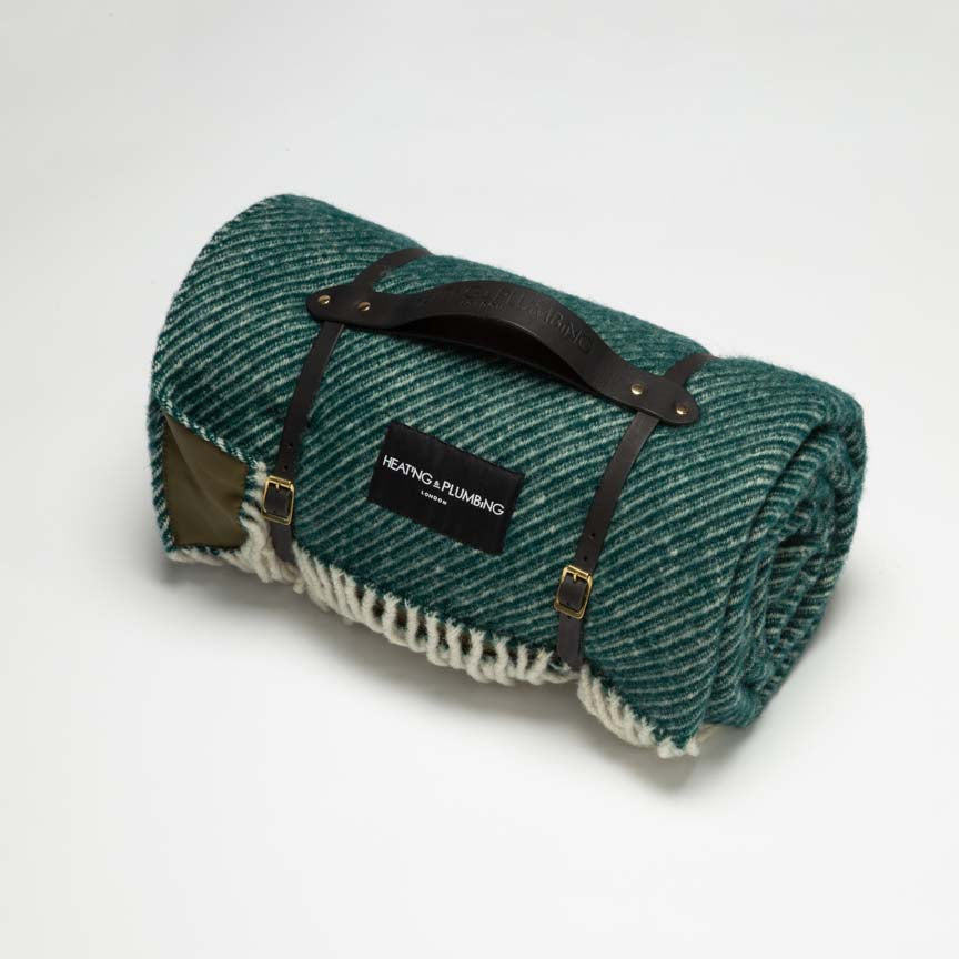 Green picnic wool blanket and waterproof backing with short black leather strap
