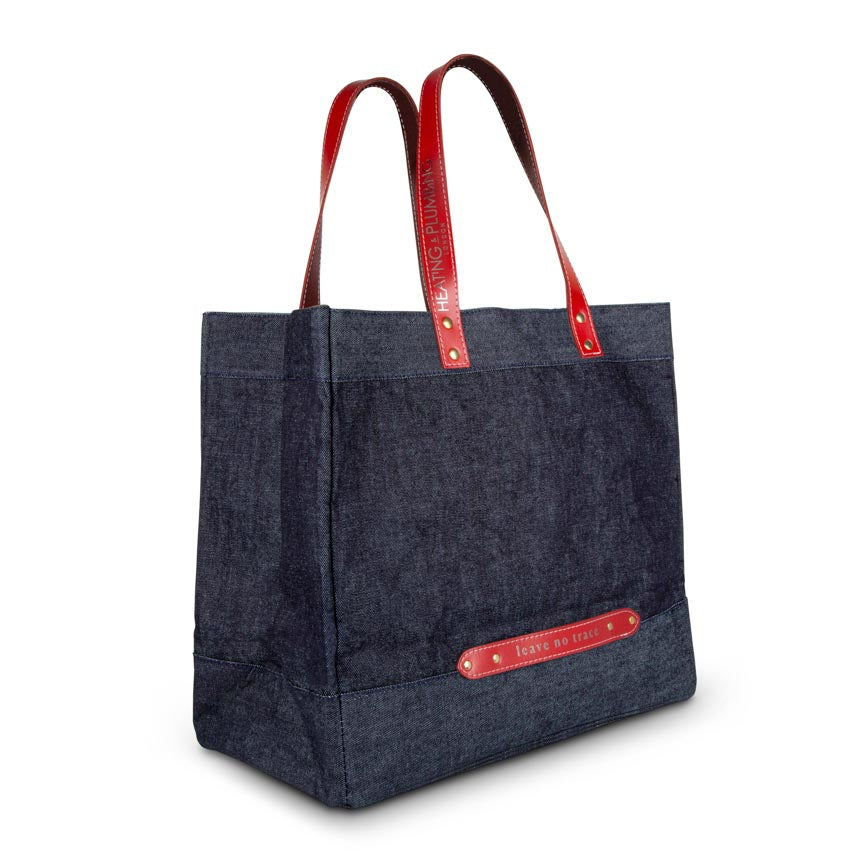 red leather handles on a large denim holdall 