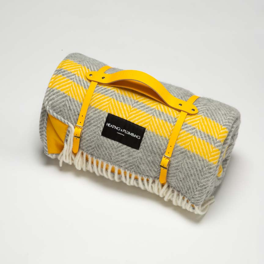 Gray and yellow picnic plaid blanket with a bright sunny yellow leather strap and a yellow waterproof backing